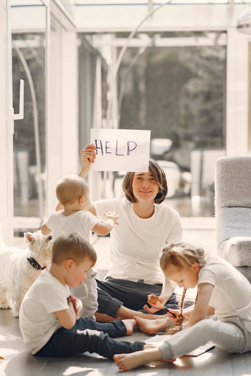 Tired mother asking for help while sitting with children